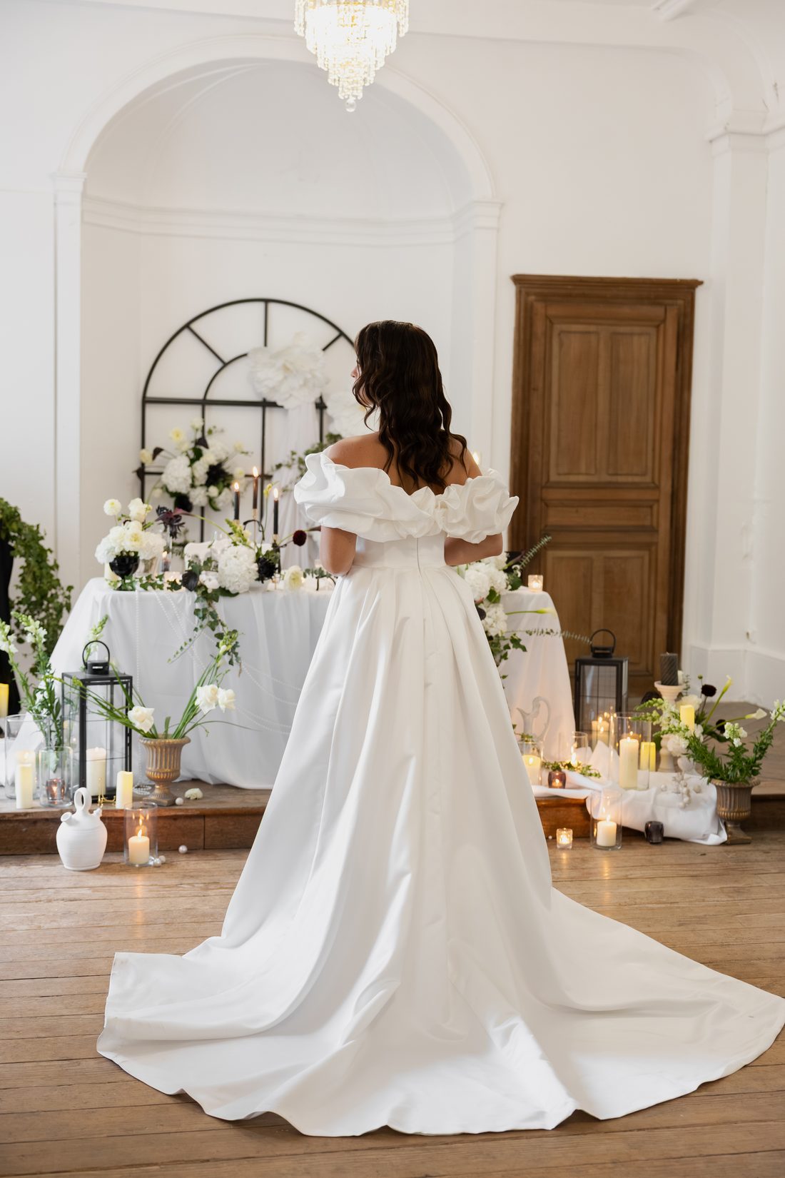 Robe satin à manches bouffantes, de dos devant une table fleurie